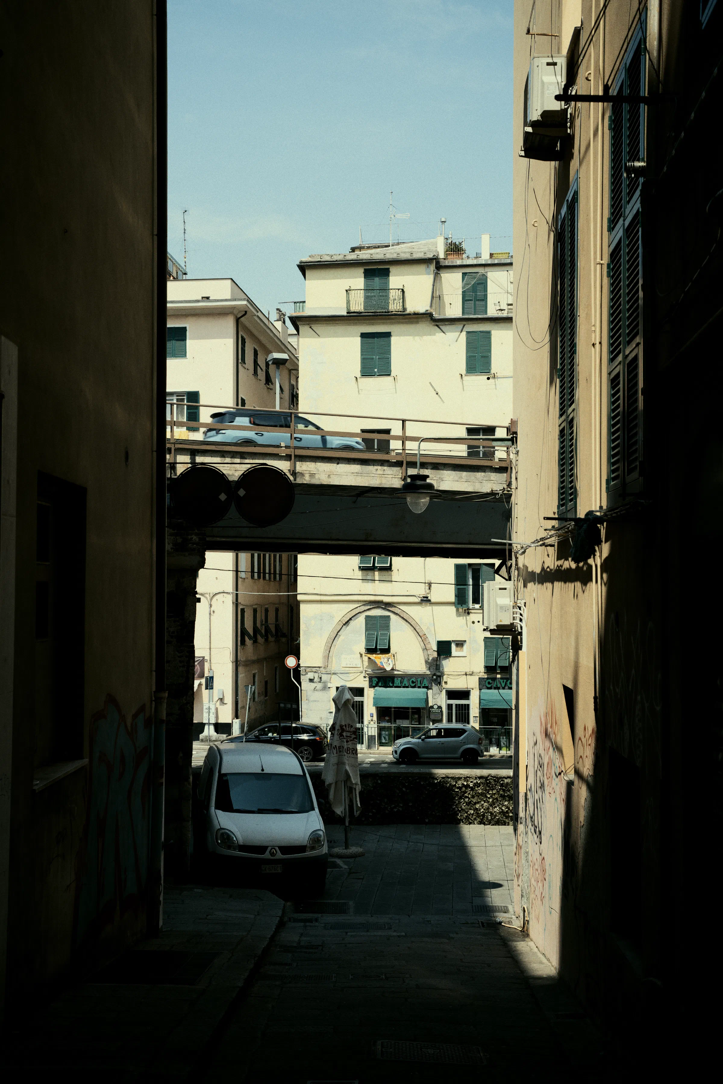 a raised highway cutting through a Genovese neighborhood, a card drives on it